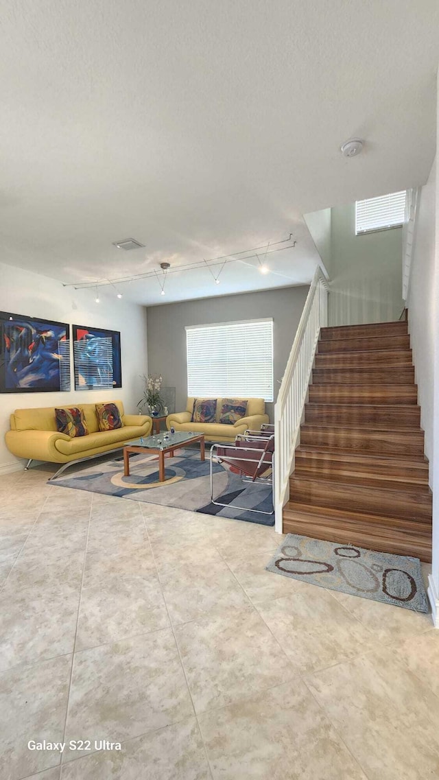 living area with stairs and track lighting