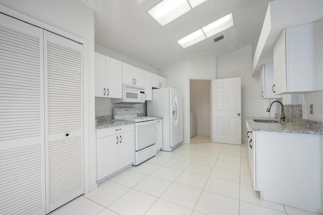 kitchen with white appliances, visible vents, lofted ceiling, white cabinetry, and a sink