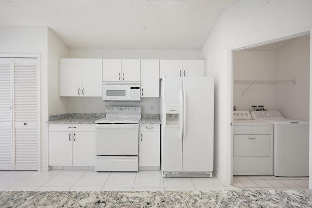 kitchen with white appliances, light countertops, washing machine and clothes dryer, and white cabinetry