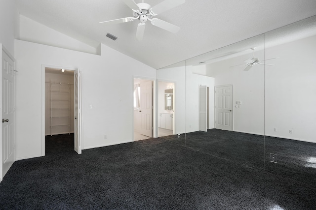 unfurnished bedroom featuring visible vents, ensuite bathroom, carpet, vaulted ceiling, and a closet