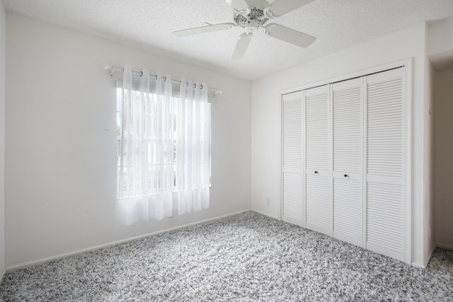 unfurnished bedroom with carpet floors, a closet, a ceiling fan, and a textured ceiling