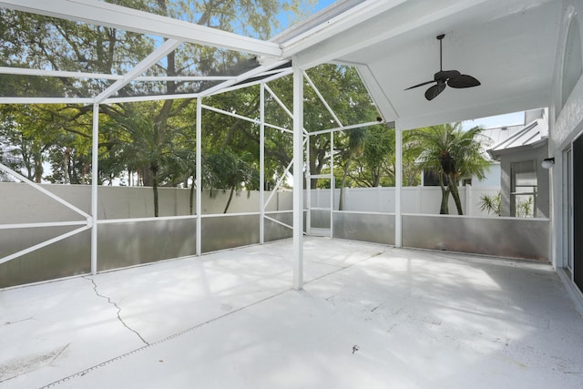 view of patio with glass enclosure, fence, and a ceiling fan