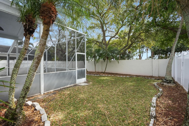 view of yard featuring a fenced backyard and a lanai