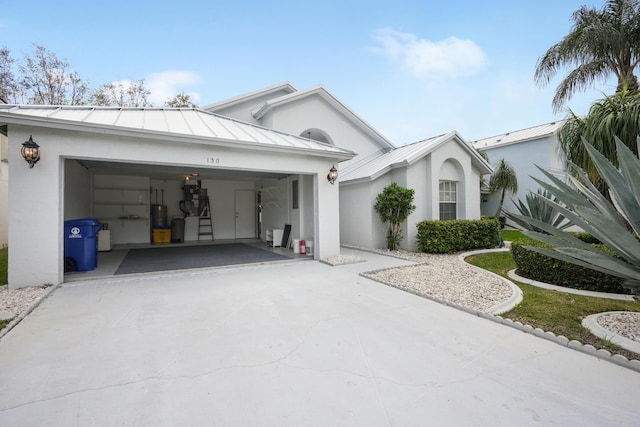 view of front facade with a standing seam roof, metal roof, and stucco siding