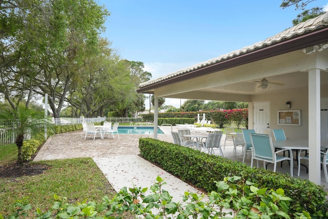 view of patio / terrace featuring a ceiling fan, outdoor dining space, a fenced in pool, and fence