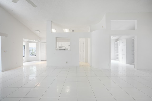 spare room featuring built in shelves, visible vents, ceiling fan, and light tile patterned floors