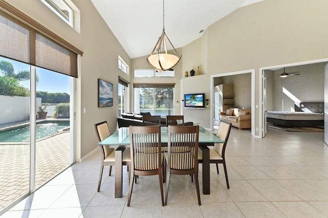 dining room with a healthy amount of sunlight, light tile patterned floors, baseboards, and high vaulted ceiling