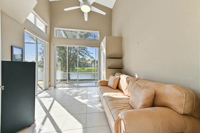 living room featuring plenty of natural light, ceiling fan, light tile patterned floors, and a water view