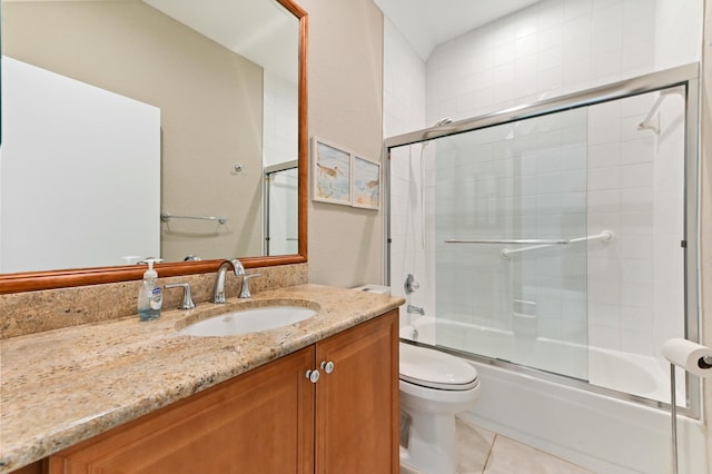 full bathroom with toilet, tile patterned flooring, bath / shower combo with glass door, and vanity