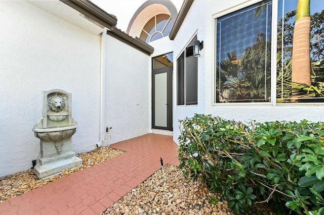 doorway to property featuring stucco siding