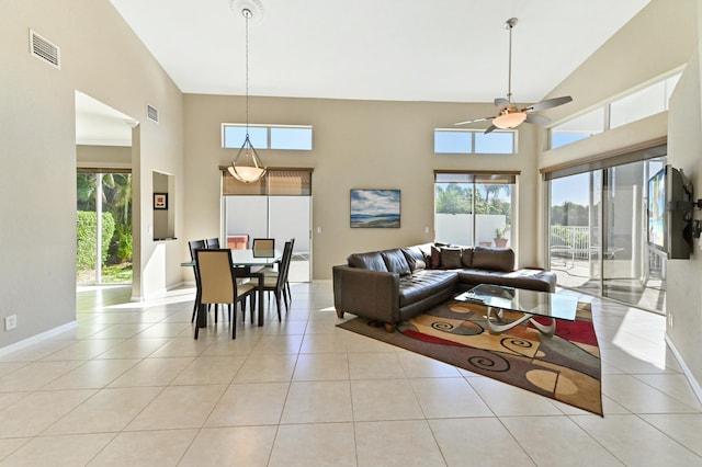 living area with high vaulted ceiling, visible vents, baseboards, and light tile patterned floors