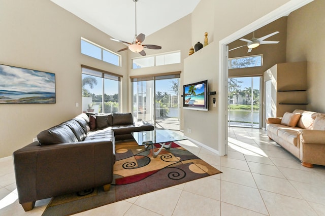 living area featuring light tile patterned flooring, a ceiling fan, and a healthy amount of sunlight