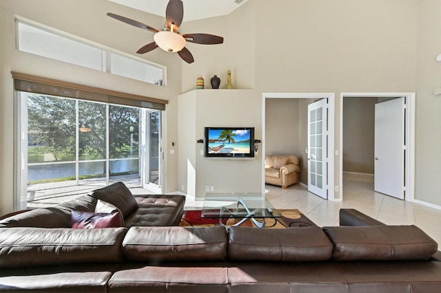 living area featuring french doors, ceiling fan, a towering ceiling, and light tile patterned floors