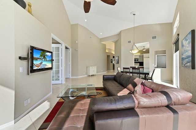 living area with light tile patterned floors, high vaulted ceiling, visible vents, a ceiling fan, and baseboards