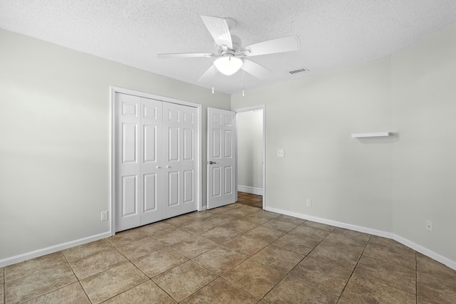 unfurnished bedroom featuring baseboards, a closet, visible vents, and a textured ceiling