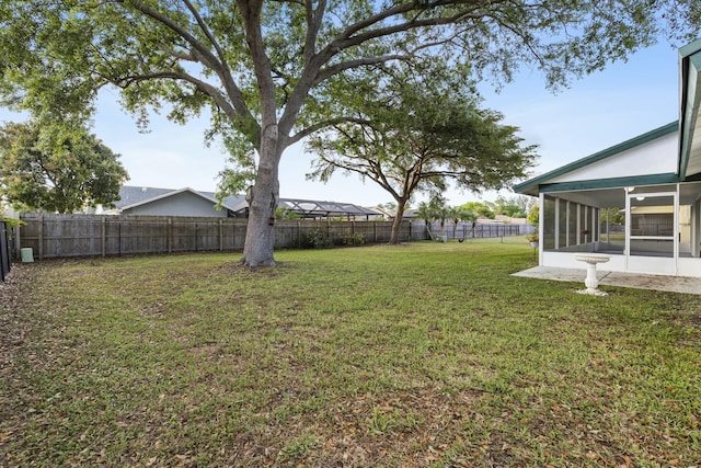 view of yard with a fenced backyard and a sunroom