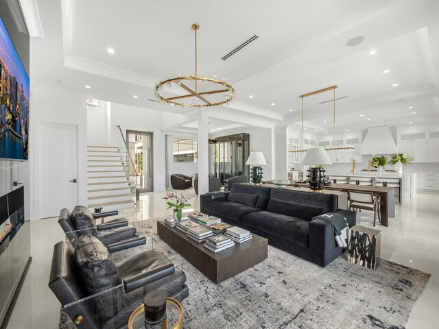 living area featuring visible vents, a chandelier, stairs, recessed lighting, and a raised ceiling