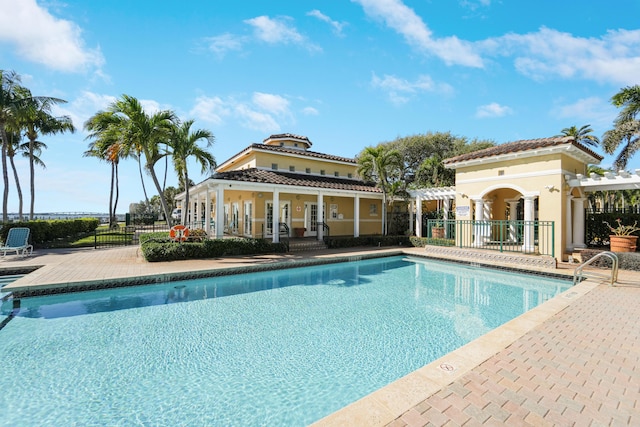 pool with a patio area, fence, and a pergola