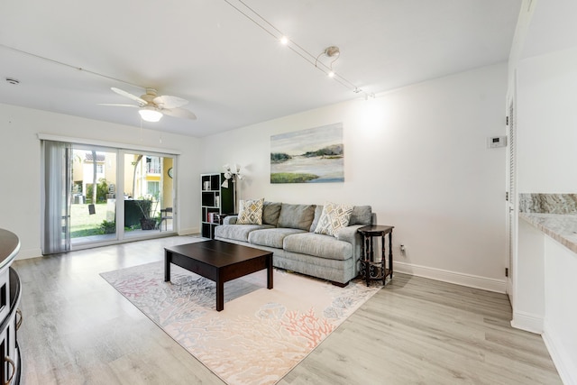 living area with a ceiling fan, french doors, light wood-style flooring, and baseboards