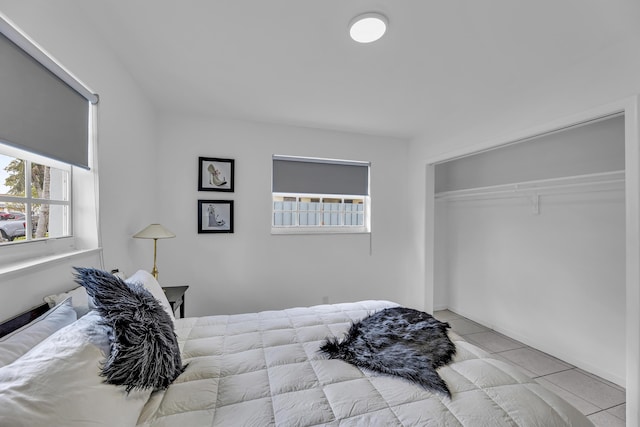 bedroom with a closet and light tile patterned flooring