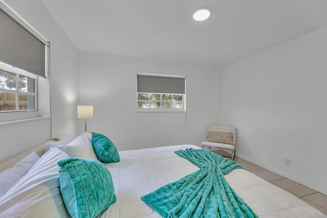 bedroom featuring multiple windows, tile patterned flooring, and baseboards