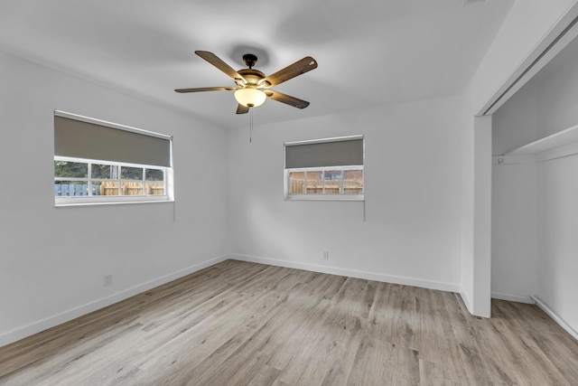 unfurnished bedroom featuring light wood-type flooring, baseboards, and a closet