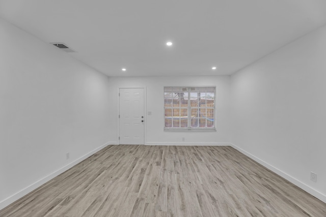 unfurnished room featuring baseboards, visible vents, light wood-style flooring, and recessed lighting