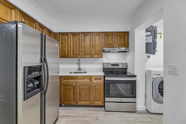 kitchen with under cabinet range hood, stainless steel appliances, a sink, light countertops, and washer / dryer