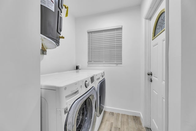 clothes washing area with laundry area, light wood-style flooring, baseboards, and independent washer and dryer