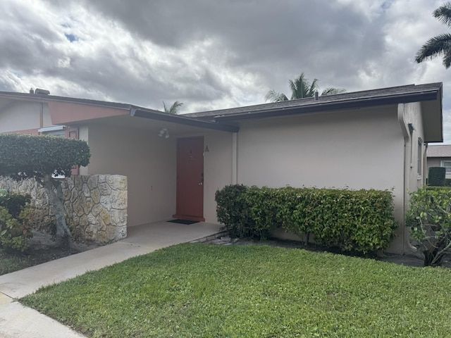 view of front facade featuring a front lawn and stucco siding