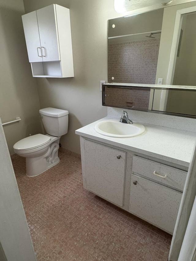 bathroom featuring vanity, toilet, and walk in shower