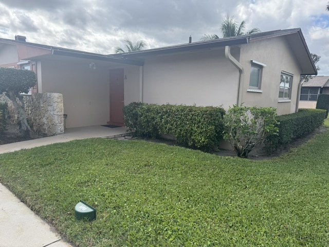 view of front of house with a front yard and stucco siding