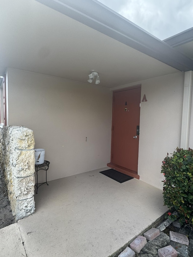 view of exterior entry featuring a patio and stucco siding