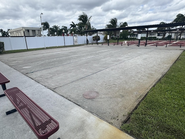 view of property's community with a tennis court and fence