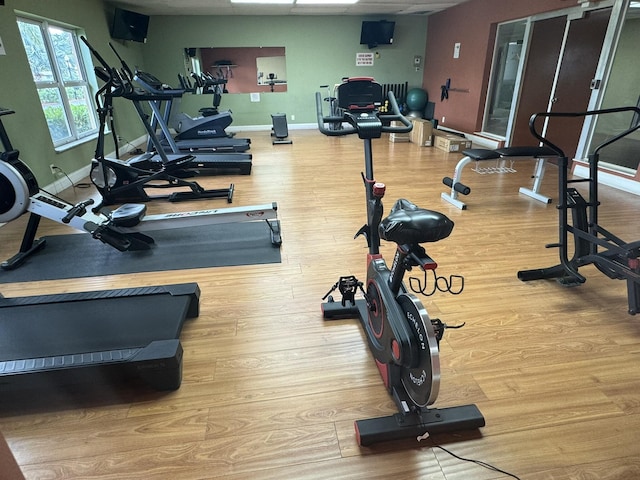 gym with light wood-type flooring and baseboards