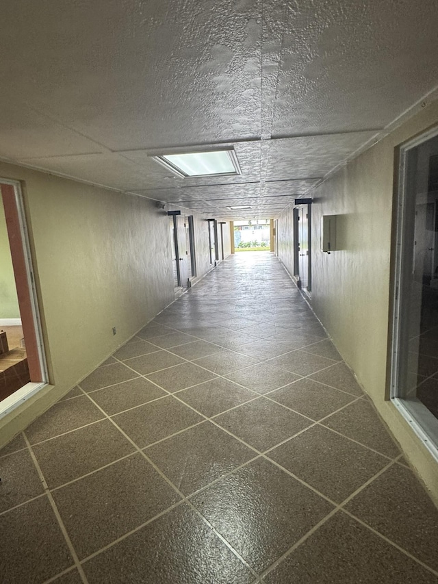 corridor featuring a textured ceiling and dark speckled floor