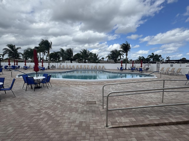 pool with a patio area and fence