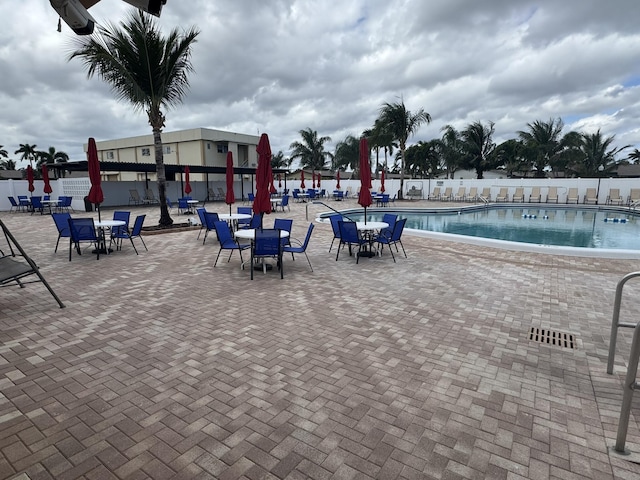 community pool with fence and a patio