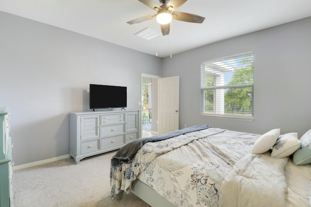 bedroom with a ceiling fan, light carpet, and baseboards