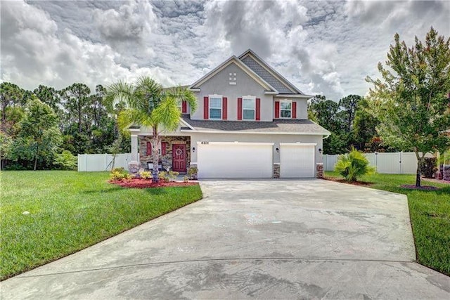 view of front of house with stucco siding, concrete driveway, an attached garage, a front yard, and fence