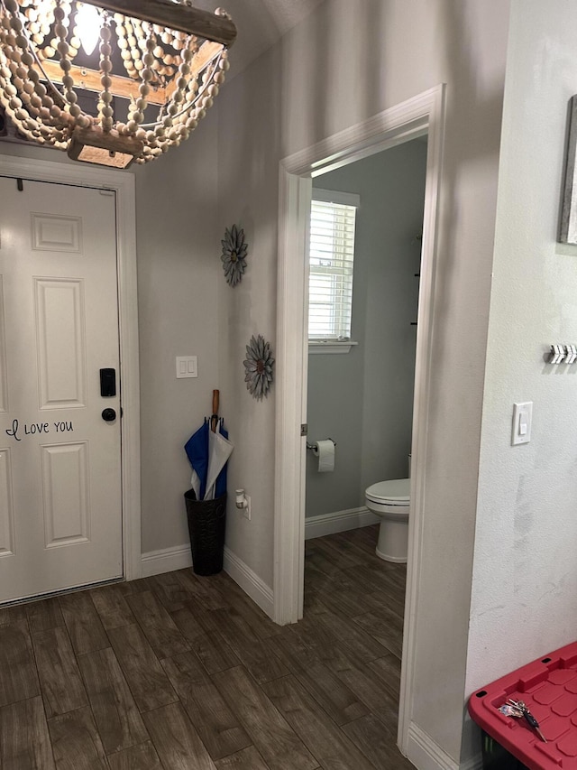 6101 NW Painted Bunting Ct, Port Saint Lucie, FL 34986 - foyer featuring dark wood-style flooring, a chandelier, and baseboards