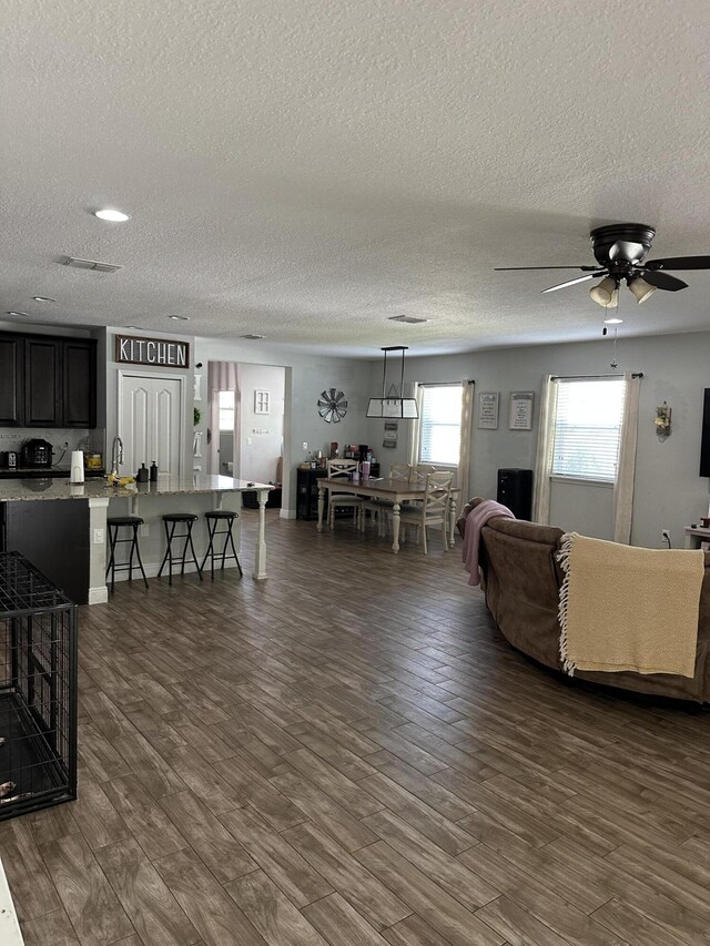 6101 NW Painted Bunting Ct, Port Saint Lucie, FL 34986 - living room with a textured ceiling, dark wood-style floors, and a ceiling fan
