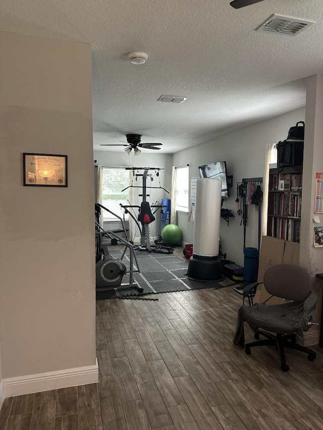 6101 NW Painted Bunting Ct, Port Saint Lucie, FL 34986 - exercise room featuring a ceiling fan, wood finished floors, a textured ceiling, and baseboards
