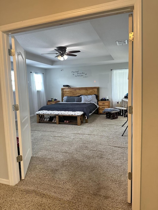 6101 NW Painted Bunting Ct, Port Saint Lucie, FL 34986 - bedroom with a tray ceiling, carpet floors, and a ceiling fan
