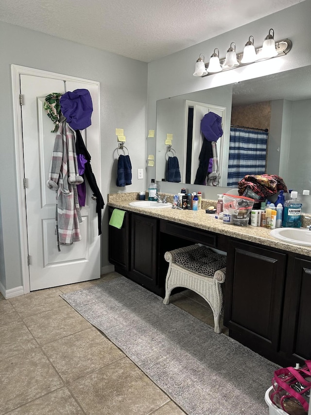 6101 NW Painted Bunting Ct, Port Saint Lucie, FL 34986 - full bathroom with double vanity, a textured ceiling, and tile patterned flooring