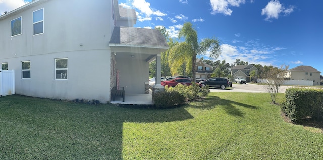 6101 NW Painted Bunting Ct, Port Saint Lucie, FL 34986 - view of side of home with a yard, stucco siding, and a porch