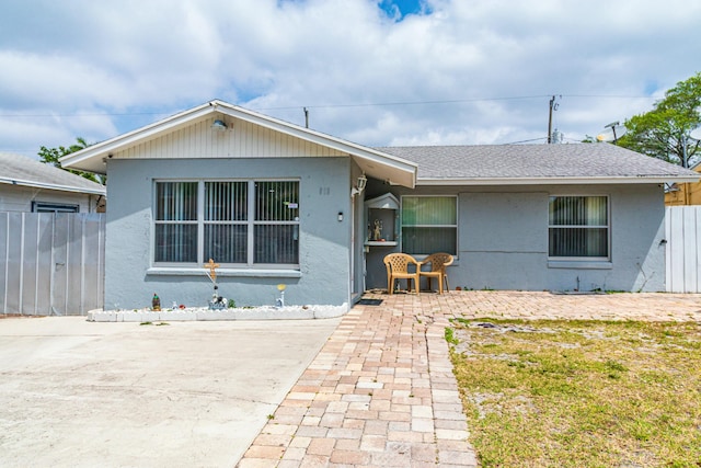 single story home with fence, a shingled roof, and stucco siding