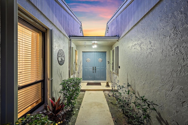 exterior entry at dusk with stucco siding