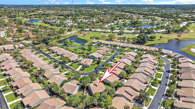 aerial view featuring a water view, view of golf course, and a residential view