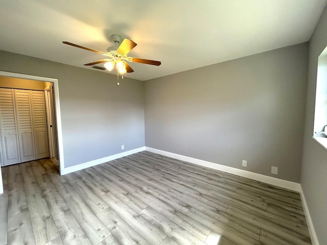 unfurnished bedroom with light wood-style floors, visible vents, baseboards, and a ceiling fan